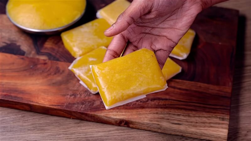 A woman is holding Jaggery Wheat Halwa in her hand