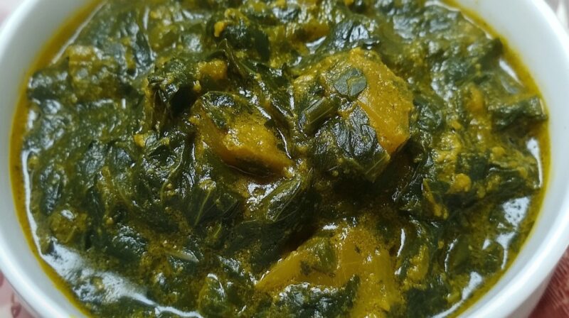 A close-up of a bowl filled with rich, creamy methi (fenugreek) leaves curry