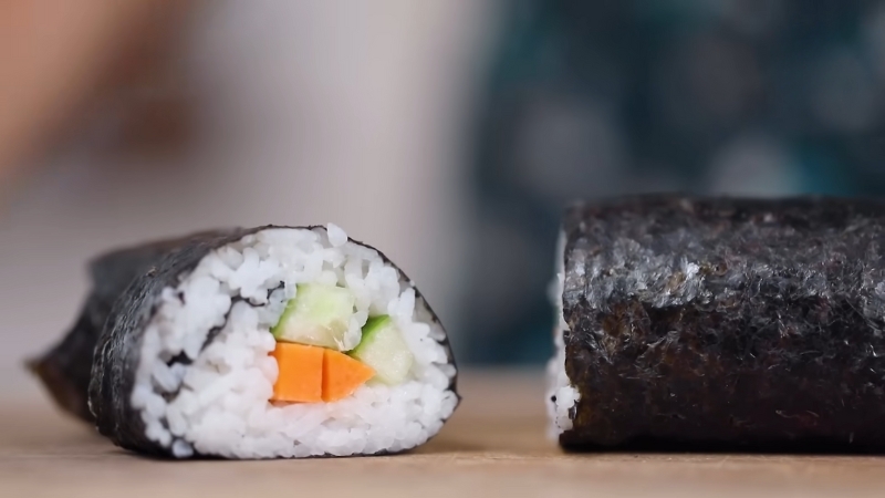 Close-Up of A Sliced Vegetarian Sushi Roll with Cucumber, Carrot, and Rice Wrapped in Nori