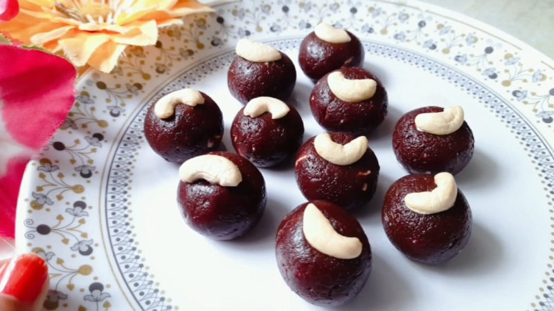 A Plate of Dark Red Carrot Beetroot Laddoos, Each Topped with A Cashew