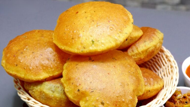 A Basket Filled with Golden, Puffed-Up Crispy Besan Poori, Served with Side Dishes in Small Bowls