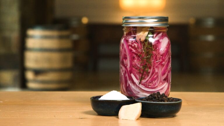 A Mason Jar Filled with Pickled Vegetables, Specifically Sliced Red Onions with Herbs