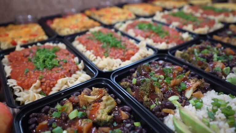 Several Containers of Vegan Meal Prep, Featuring Pasta with Marinara Sauce, Black Beans with Rice, and Broccoli with Green Onions