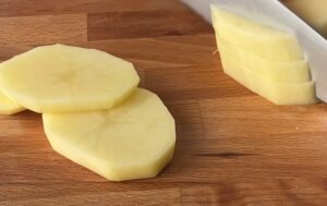 Potatoes sliced on a chop board