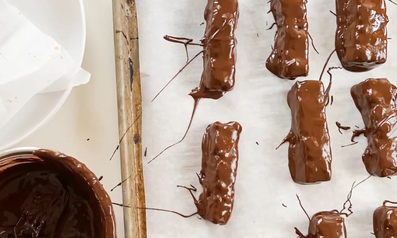 Chocolate-covered pretzels arranged neatly on a baking sheet