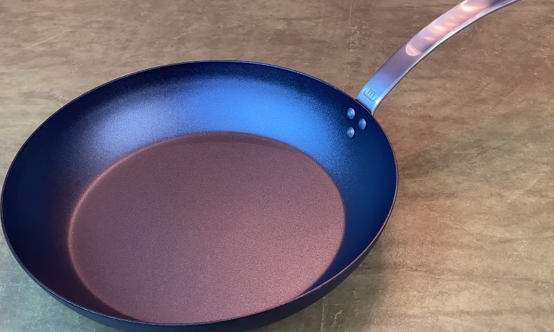 A covered pan resting on a wooden table