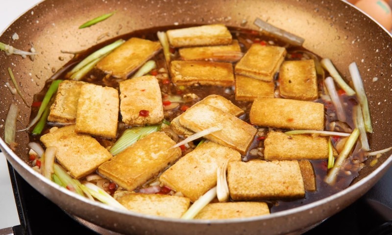Chinese tofu stir fry in a pan, featuring colorful vegetables and tofu pieces