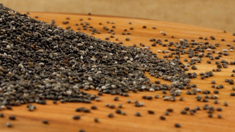 Chia seeds spread across a wooden surface
