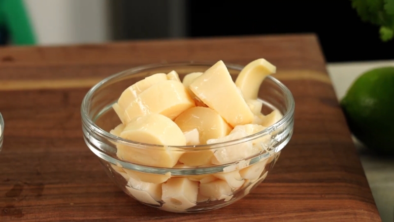 Chopped hearts of palm in a glass bowl, ready for seasoning and cooking