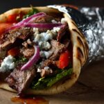 Grilled meat gyro wrapped in pita with vegetables and cheese
