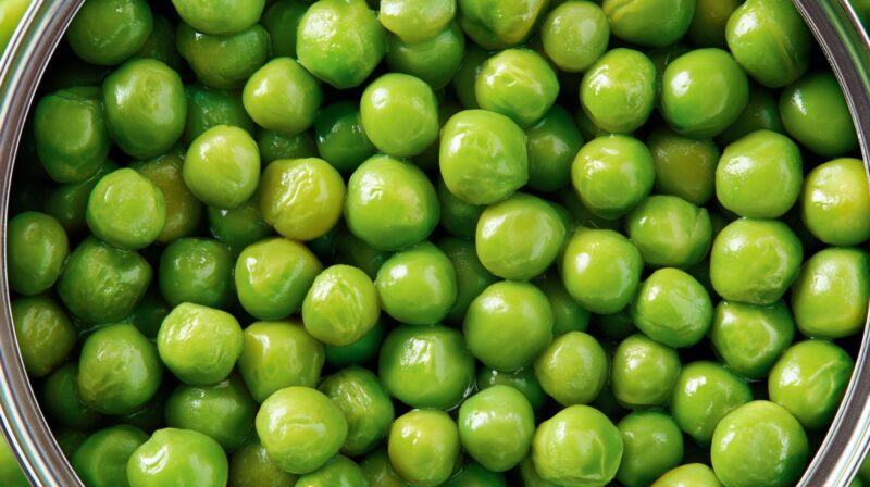 Close-up of green peas packed tightly inside a metal can