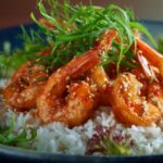 Plant-based shrimp served over rice with glossy sauce, sesame seeds, and fresh herbs