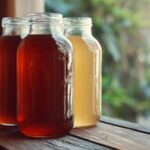 Jars of homemade tea showing colors similar to popular kombucha brands on a wooden table