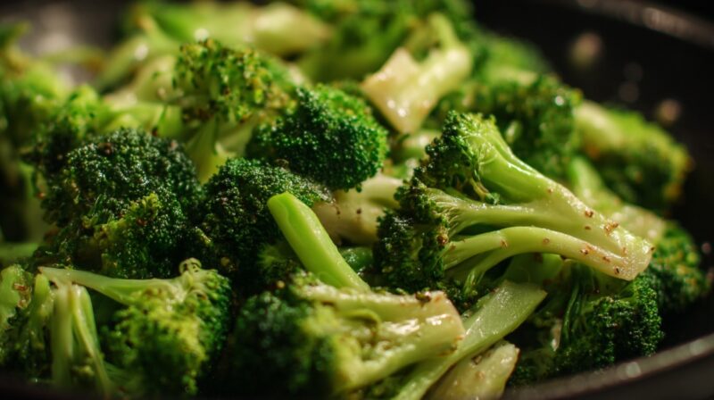 Close-up of broccoli florets cooking in a pan with light seasoning
