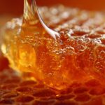Close up of honey flowing over textured honeycomb cells