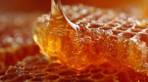 Close up of honey flowing over textured honeycomb cells